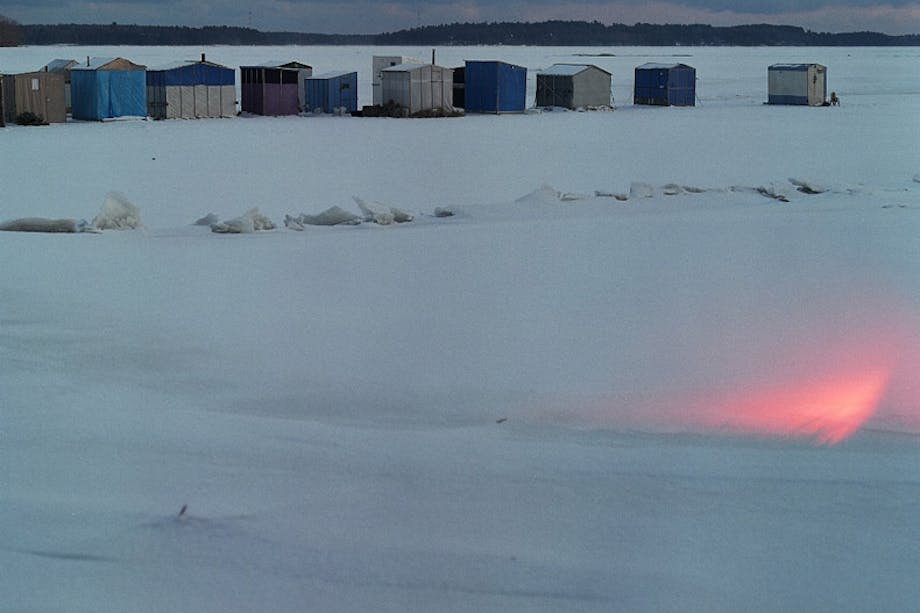 line of small structures in frozen tundra at sunset