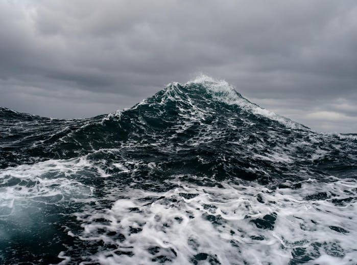 Filson Life - Photographer Corey Arnold. large sea wave rises toward the clouds like a mountain