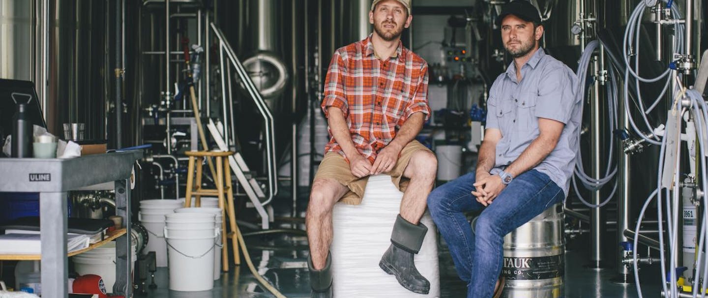 two guys sitting in a brewery