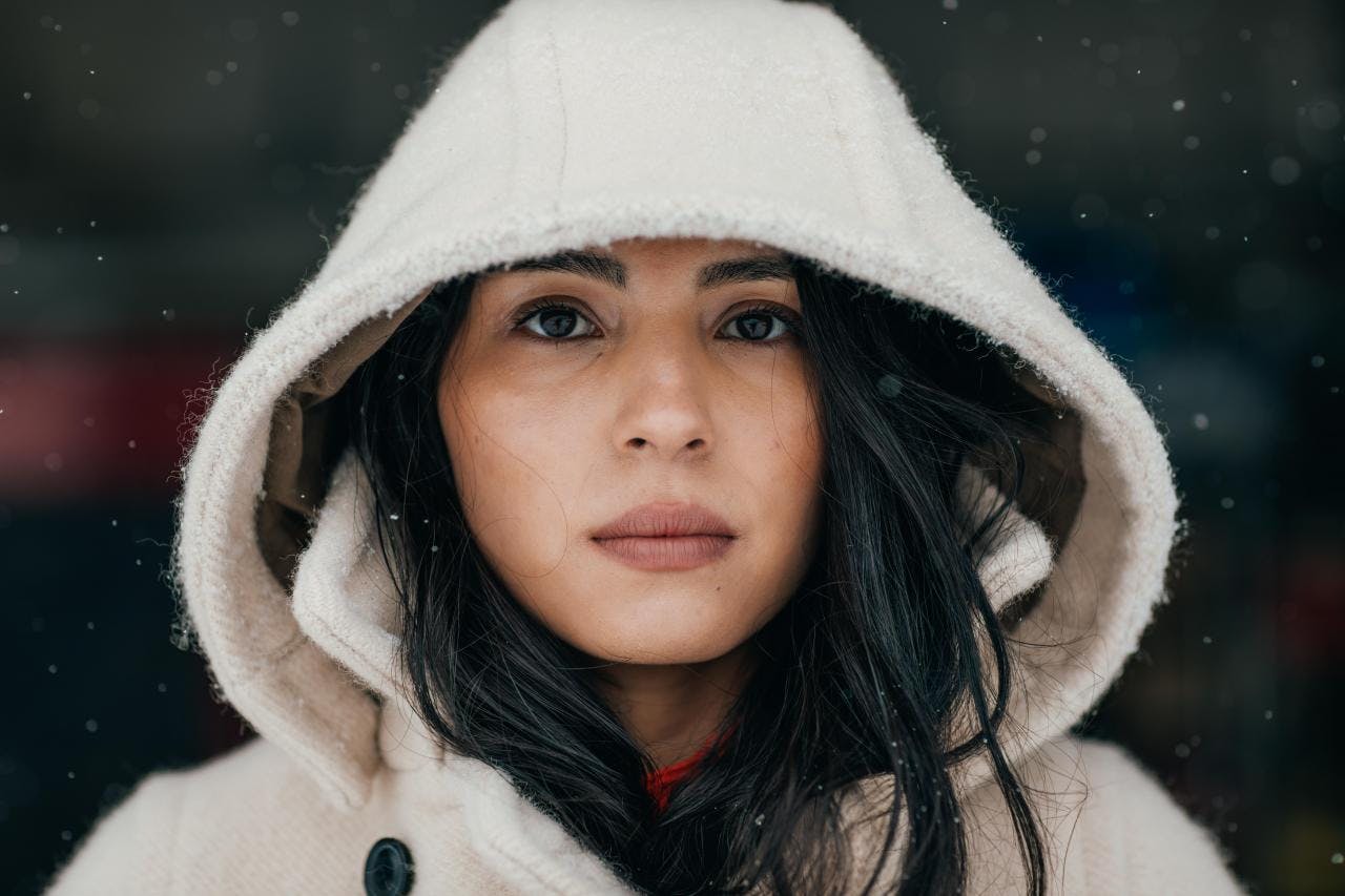 Keya portrait in white wool hooded jacket falling snow