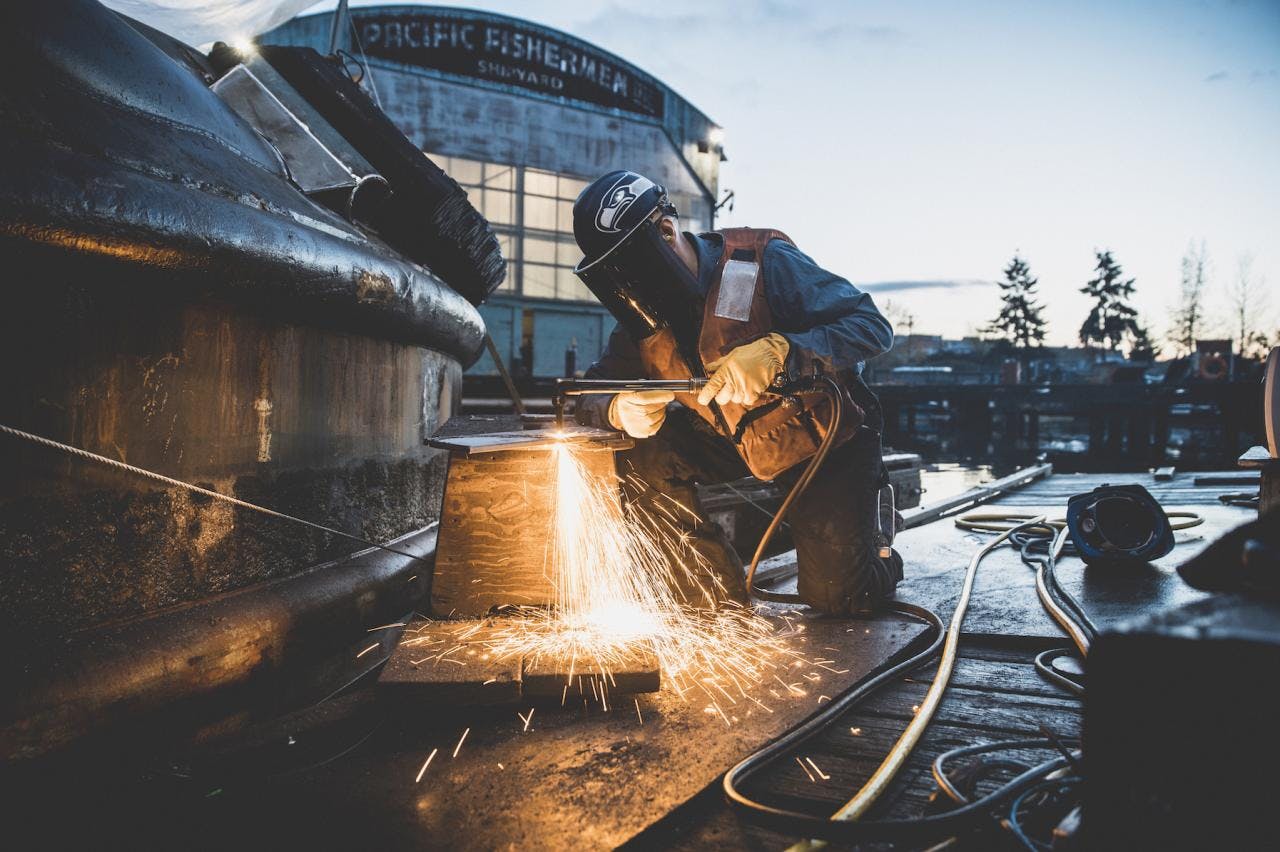 Man welding with sparks flying in the Pacific Fisherman Shipyard located in Ballard, WA.