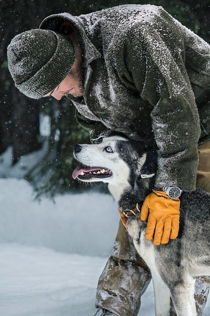 Filson Life - Elliot Anderson - Dogsledding dog with master in filson black coat and gloves