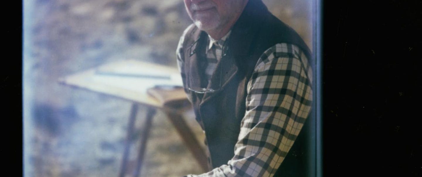 Eric Blinman, Archaeologist portrait through door window wearing vest and plaid shirt