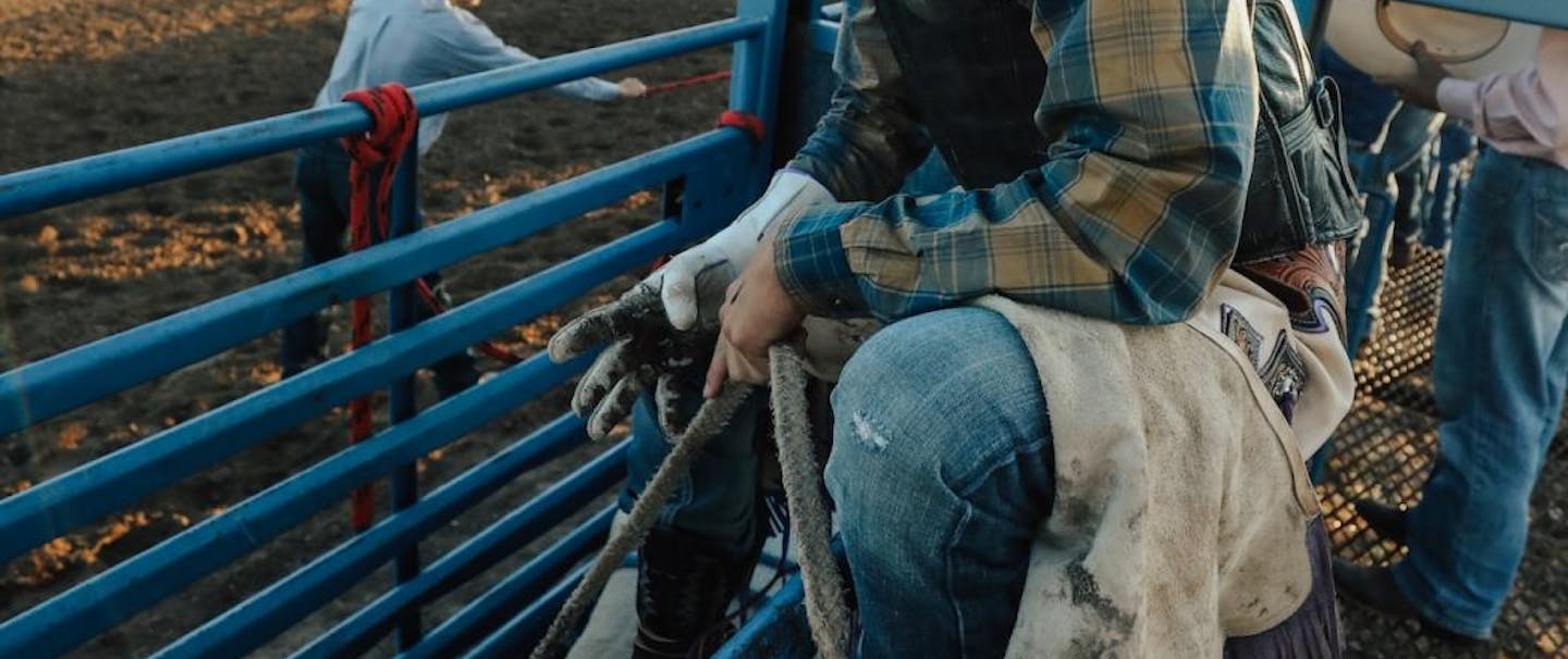Garrett sitting on the fence ready to ride a bull