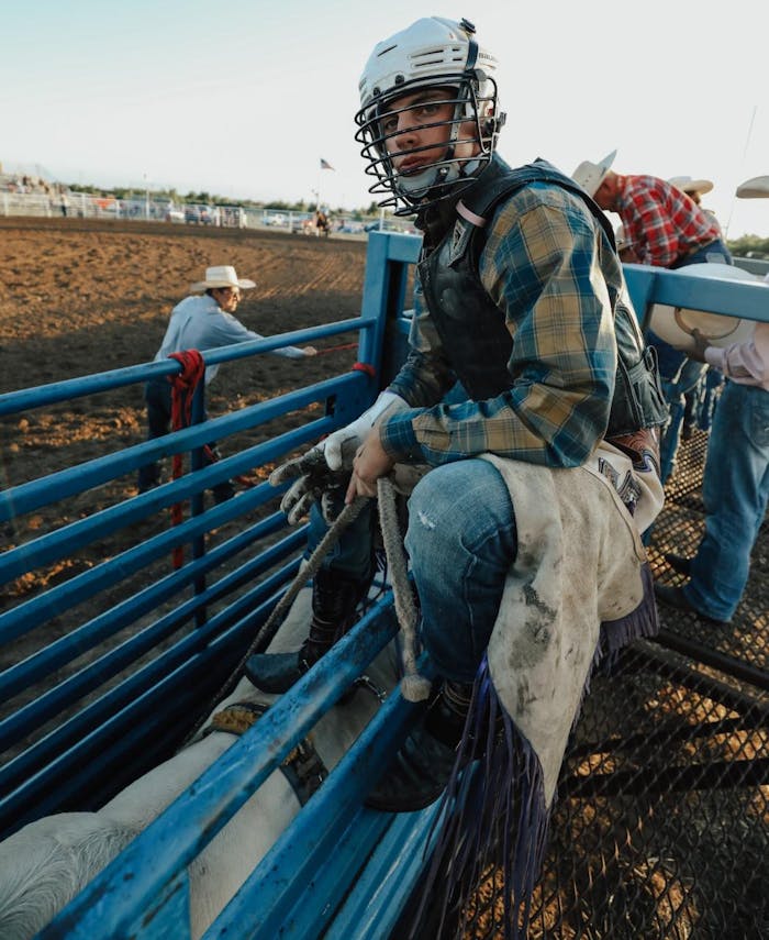 Garrett sitting on the fence ready to ride a bull