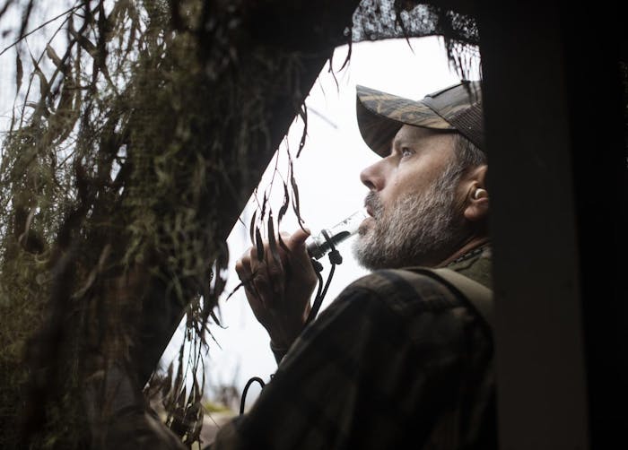man looking out of a duck blind