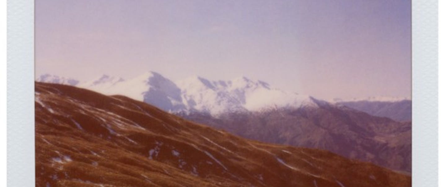 New Zealand polaroid of snowy mountains and green hills