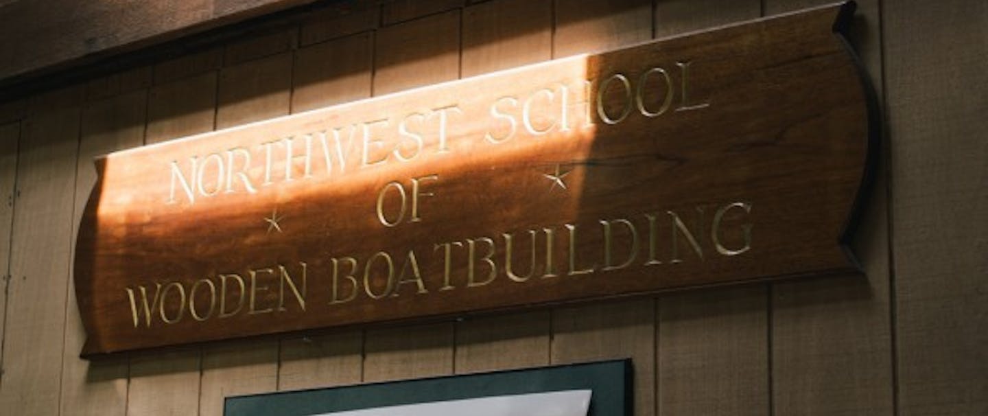 Wooden plaque on wall reads Northwest school of wooden boatbuilding