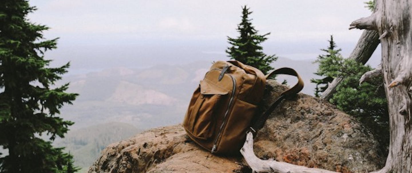 Filson backpack rests on a rock overlooking a valley
