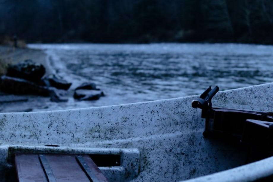 boat in lake with foggy pine treeline backdrop