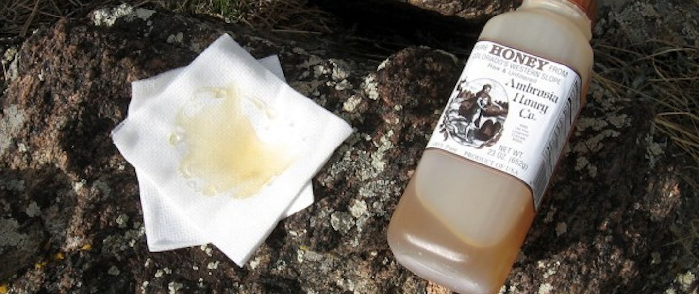 bottle of honey next to cloth with honey on it