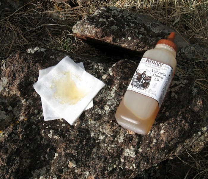 bottle of honey next to cloth with honey on it