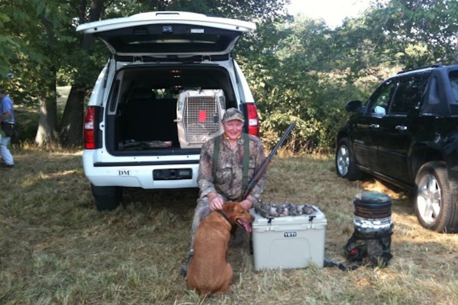hunter sitting at car with gear and dog