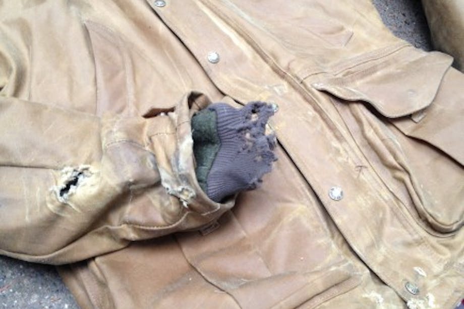 partially ripped tin cloth motorcycle jacket shows the results of a crash