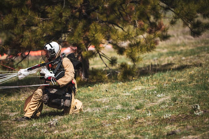 smokejumper firefighter safely landing from practice jump in grassy field