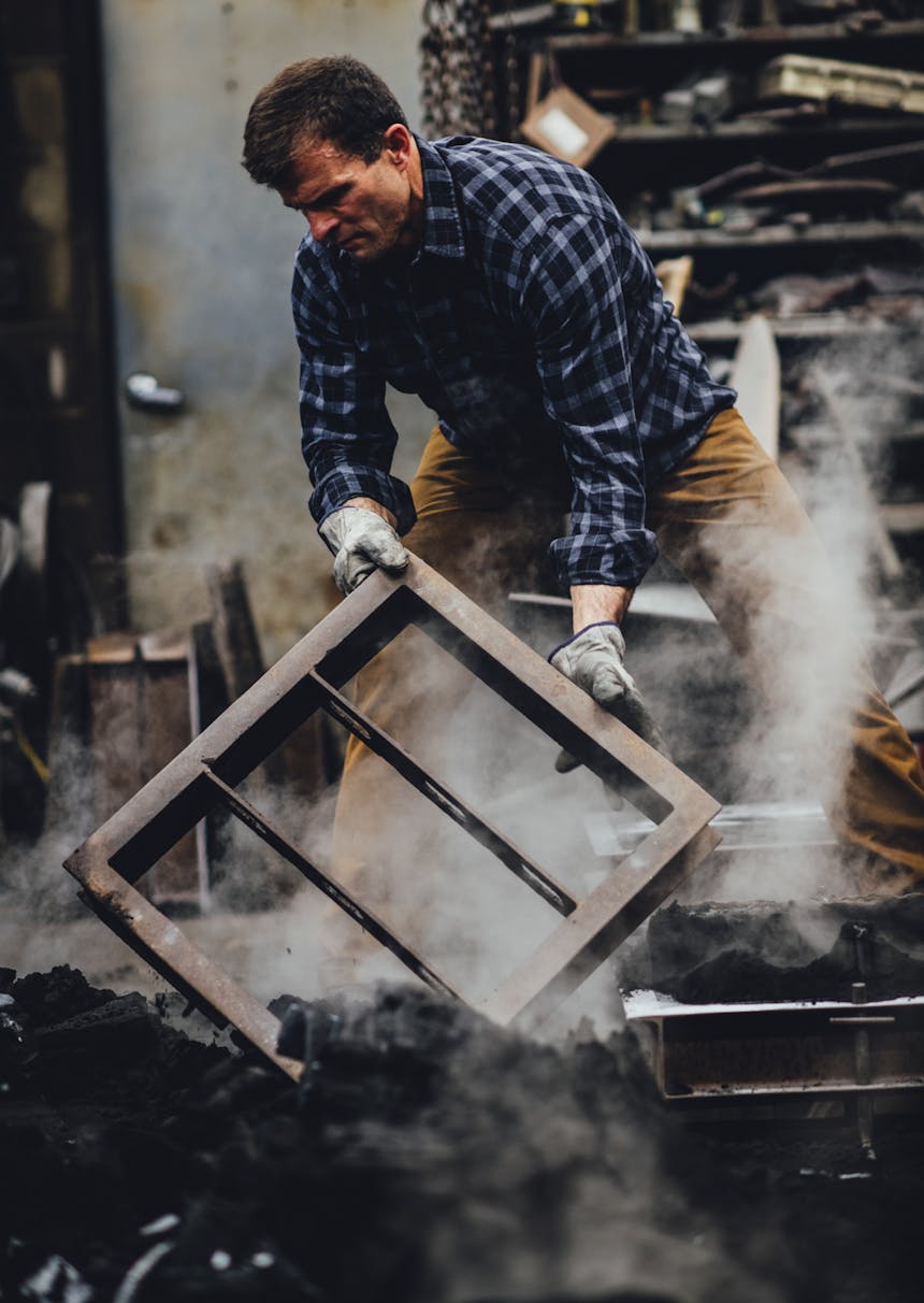 man moving metal in foundry