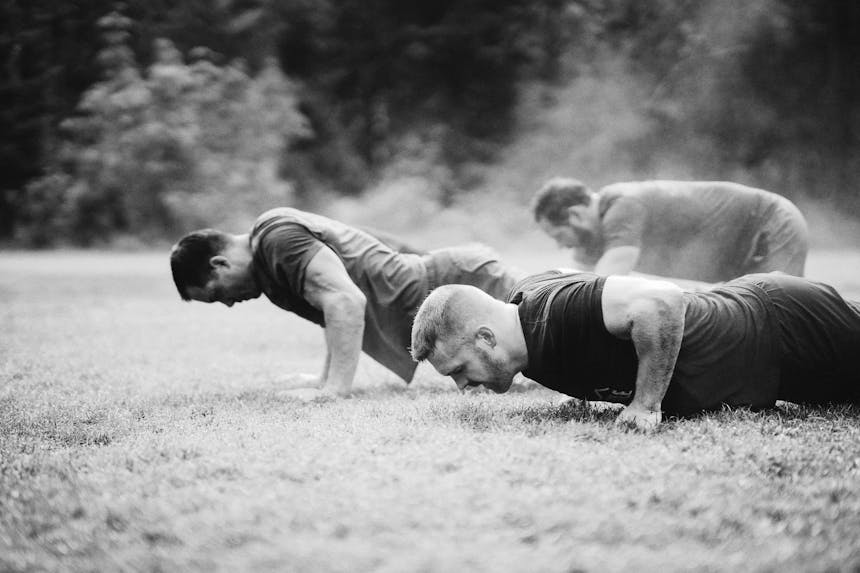 close up of men working hard to complete pushups
