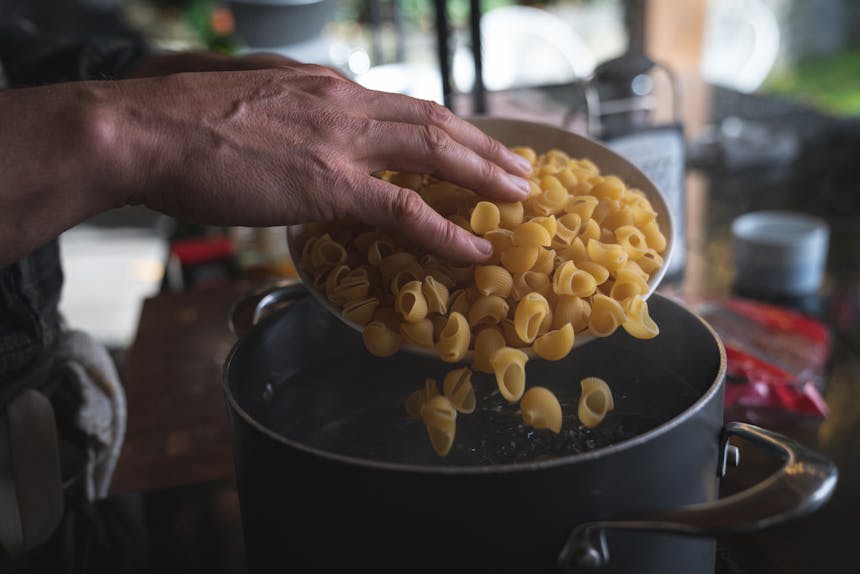 adding pasta shells to boiling water