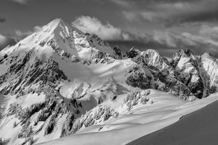 a black and white image of a snowy mountain peak landscape