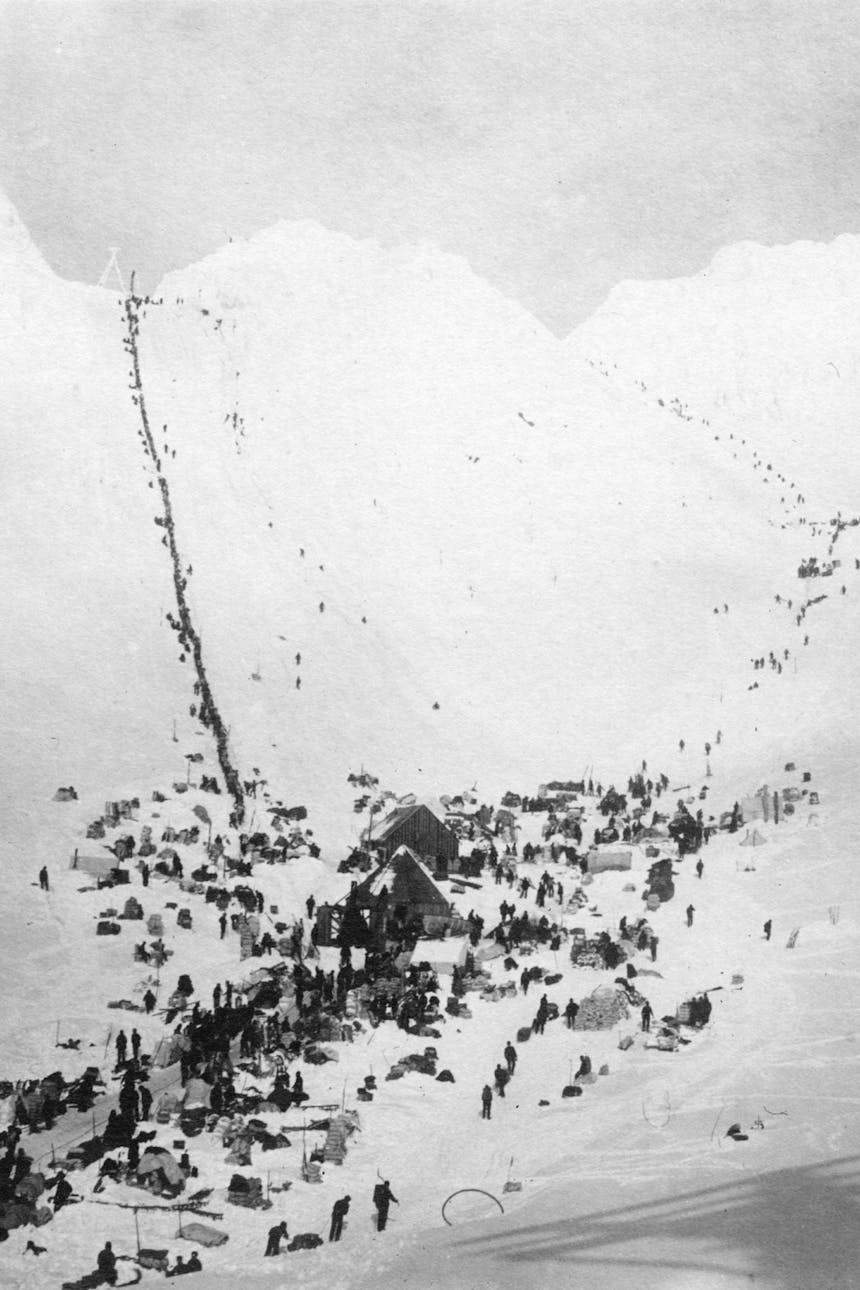 historic black and white image looking down a hill into a village