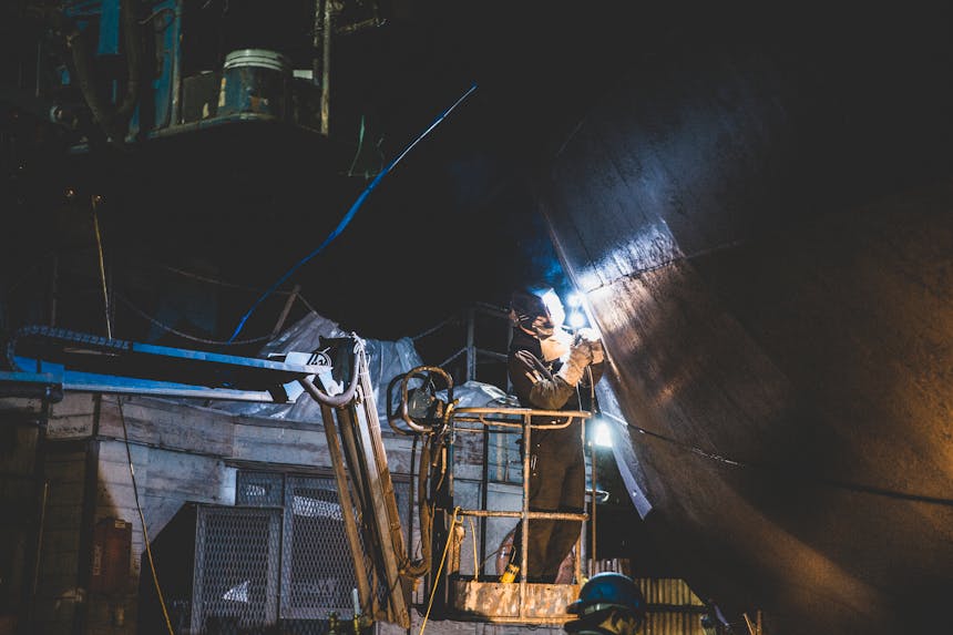 welder working on ship hull at night at pacific fisherman shipyard