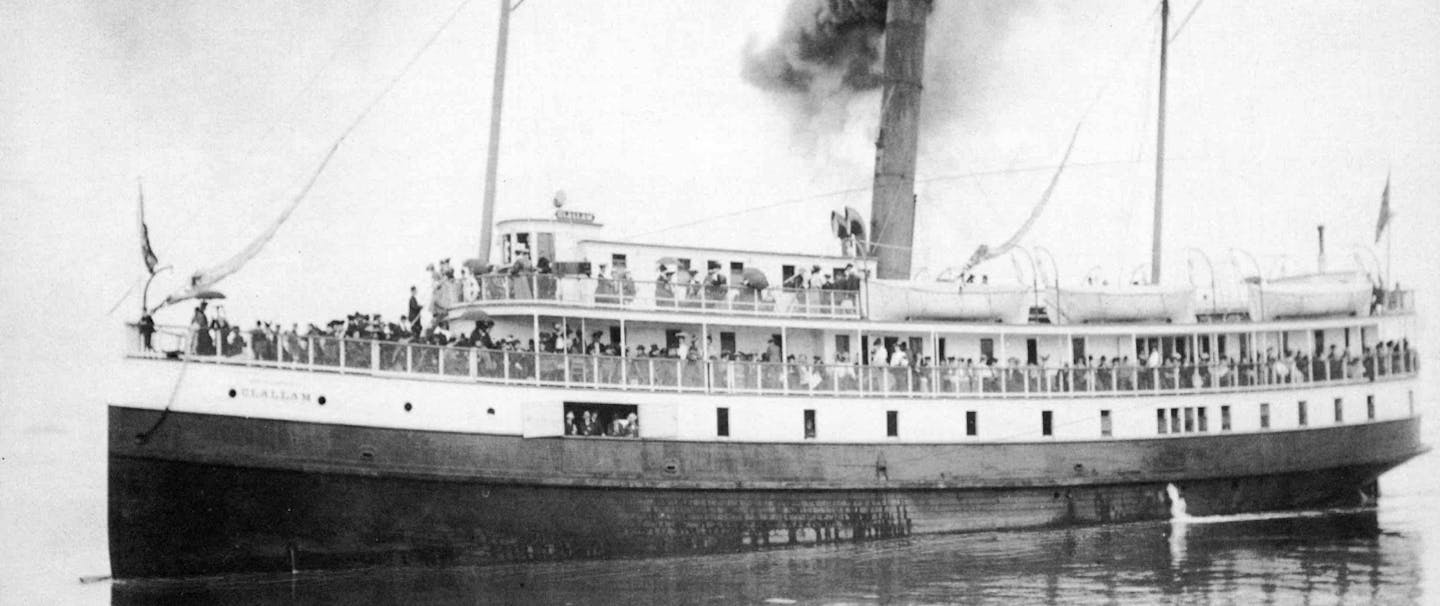 vintage black and white image of a large double decker steam ship SS Clallam at sea with many people lining the railings