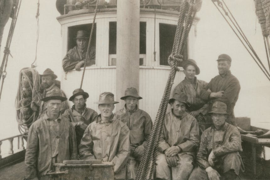 vintage black and white image of 8 members of the Deep Sea Fishermens union on their boat in uniforms