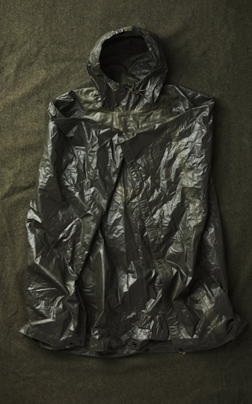 top down view of rain coat folded lying on a cloth covered table