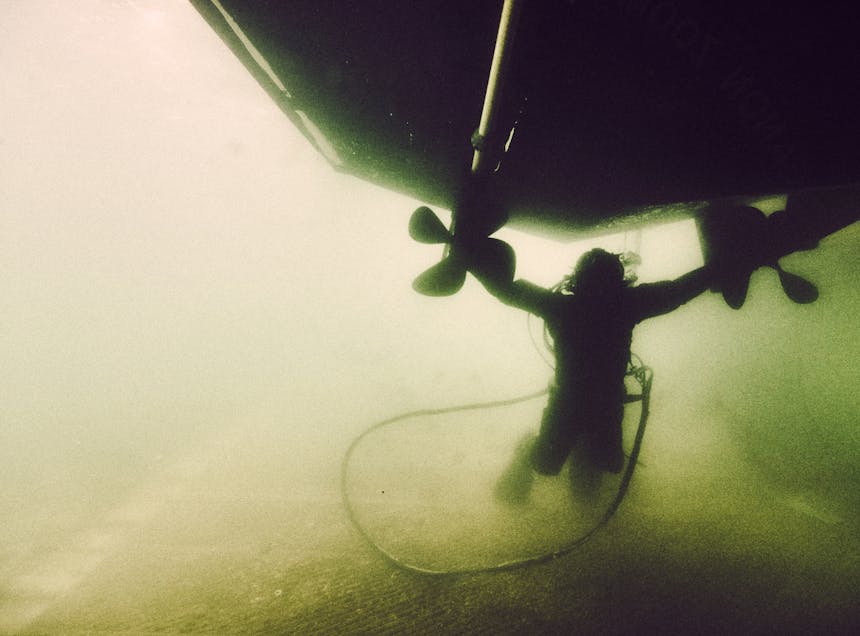 underwater view of dual propeller boat in greenish water