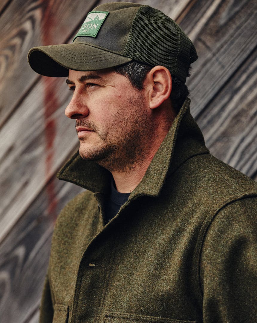 man in filson trucker hat and olive colored coat