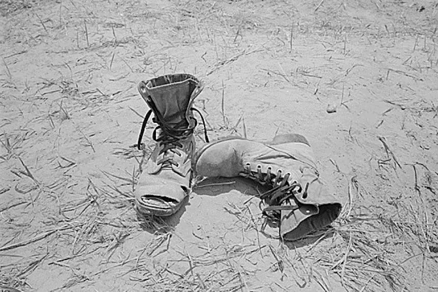 black and white boots on a dusty and grassy ground