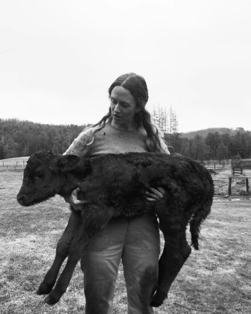 woman holding a baby cow