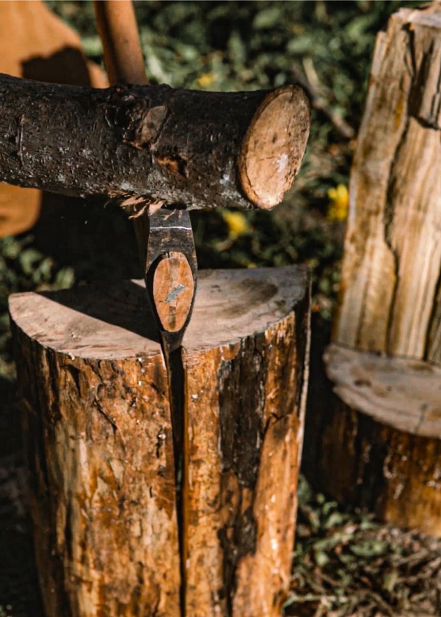 using a log to force an axe through a log to split it