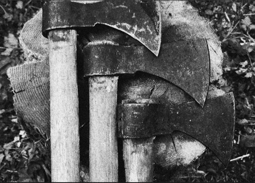 three tomahawk axes laid on top of a wood stump