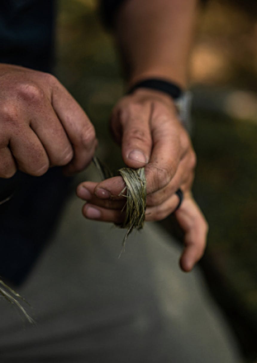 hand wrapping stinging nettle cordage around three fingers