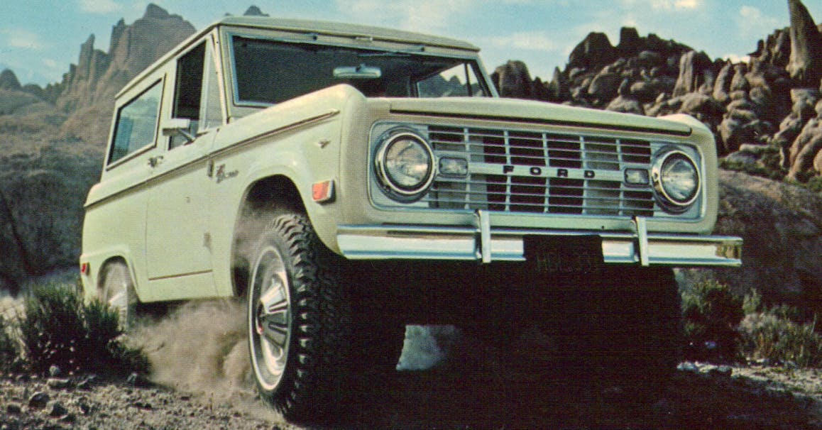 white ford bronco at a mountain pass with craggy stone cliffs in the background
