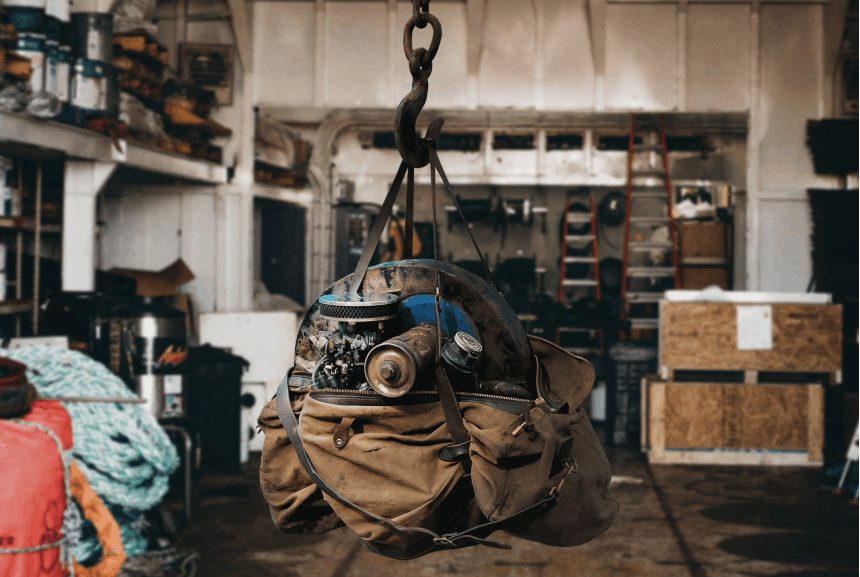 店の真ん中にあるフックからぶら下がっている黄褐色のフィルソンダッフルバッグの機械部品