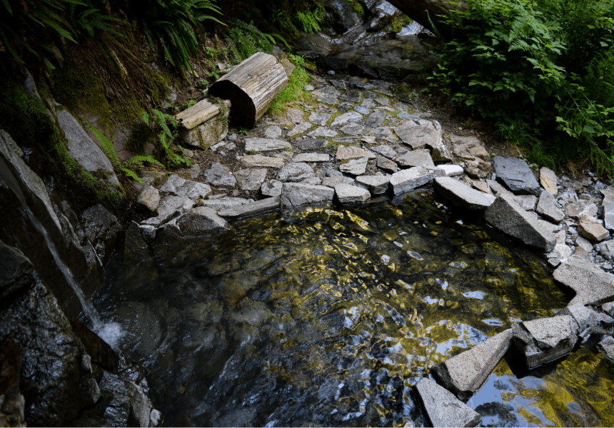 a shimmering pool of water lined by angular rock slabs