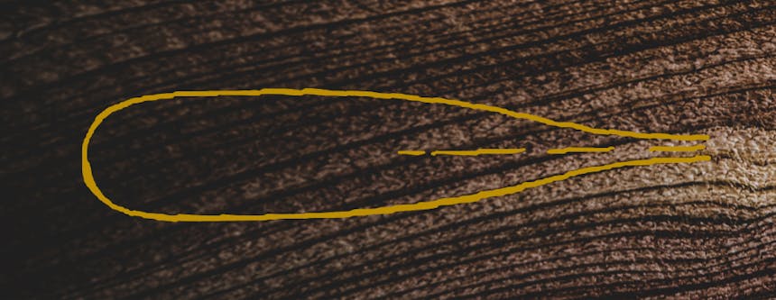 yellow line drawn in the shape of an oar paddle on wood grain