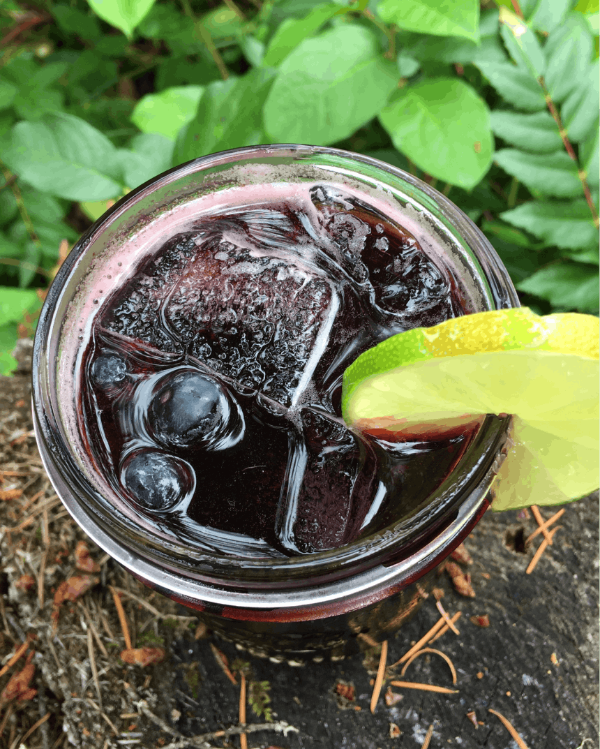 crimson tide cocktail red liquid with lime wheel on lip of mason jar