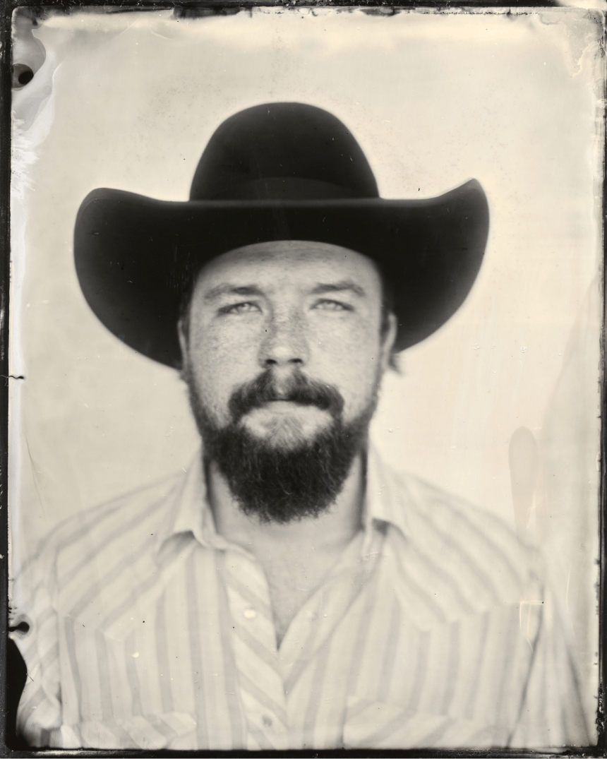 black and white portrait of man in black cowboy hat with beard