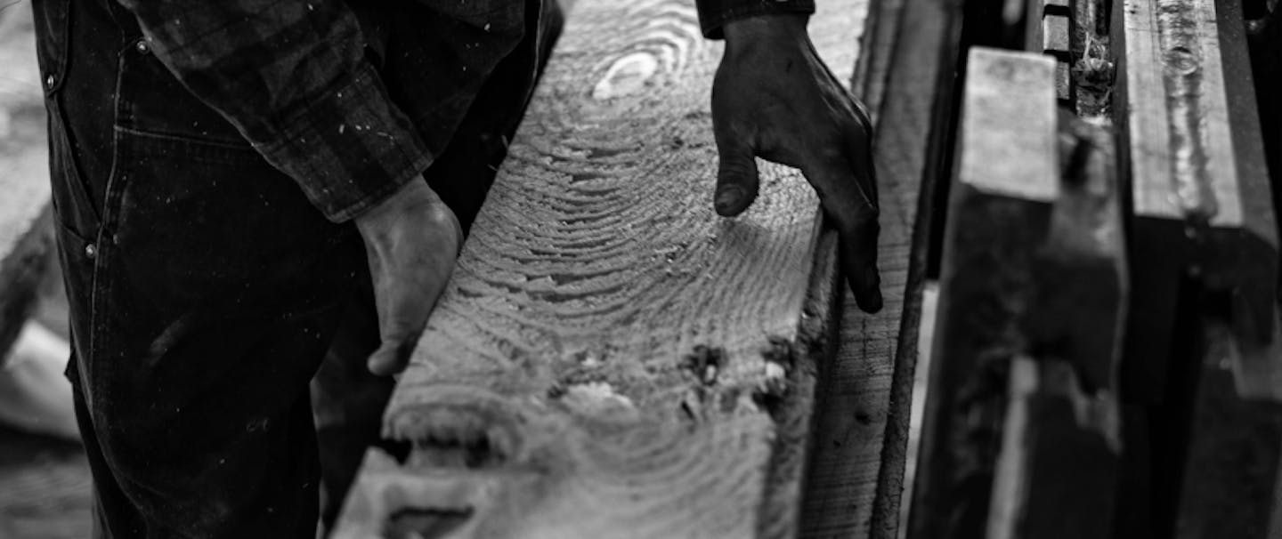 hands holding a long freshly milled board