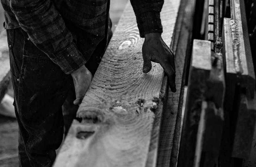 hands holding a long freshly milled board