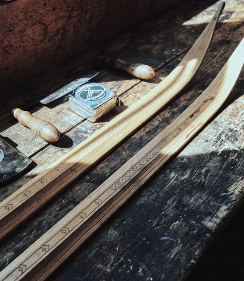 wooden cross country skis being built and honed on a wooden table