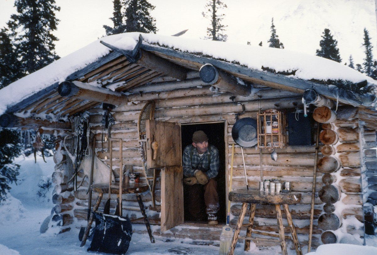 Richard Proenneke in his snow covered cabin in the forest