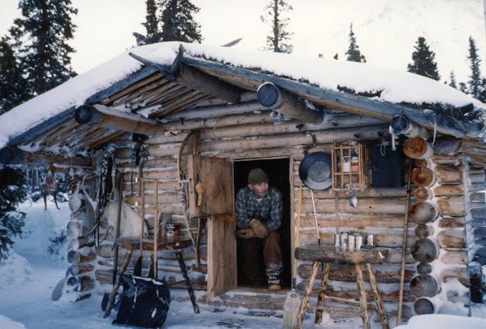 Richard Proenneke in his snow covered cabin in the forest