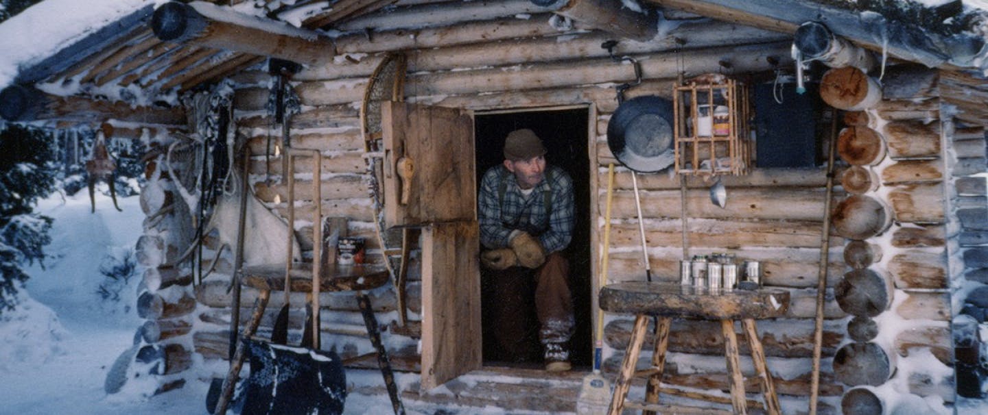 Richard Proenneke in his snow covered cabin in the forest