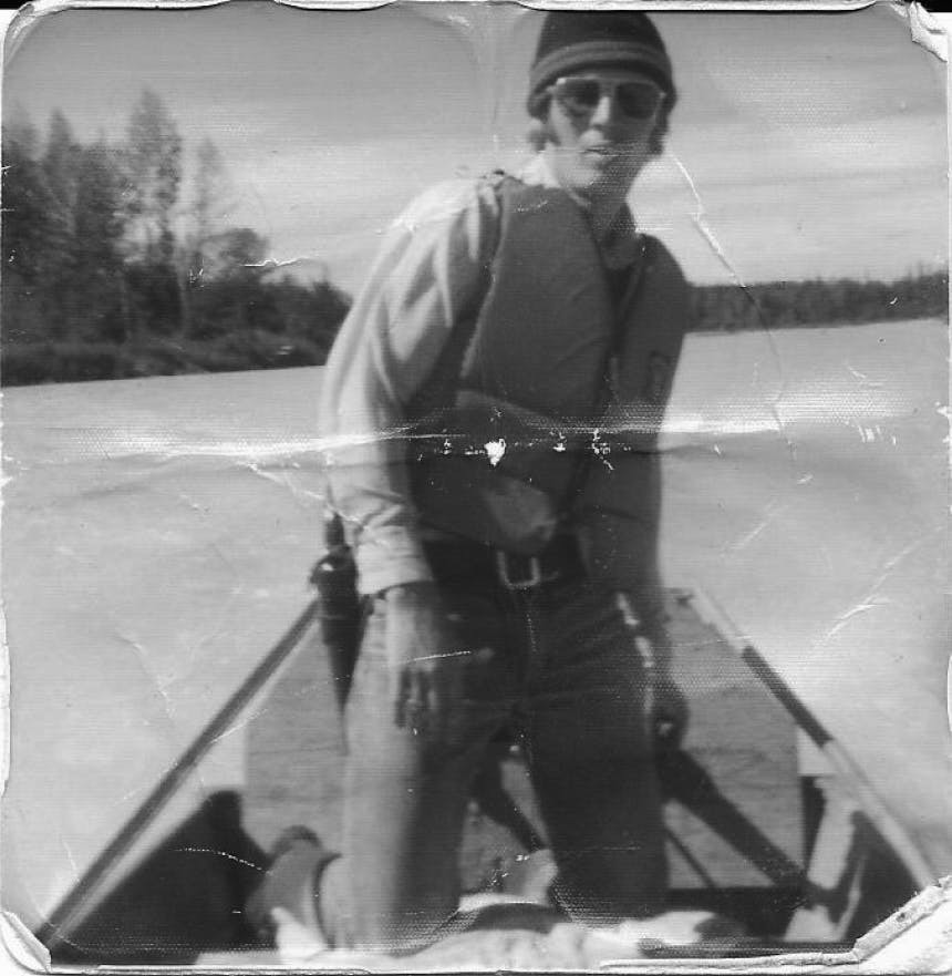 black and white portrait of man in life vest on a boat