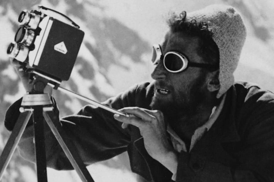 man in glacier goggles looking through an old fashioned video camera