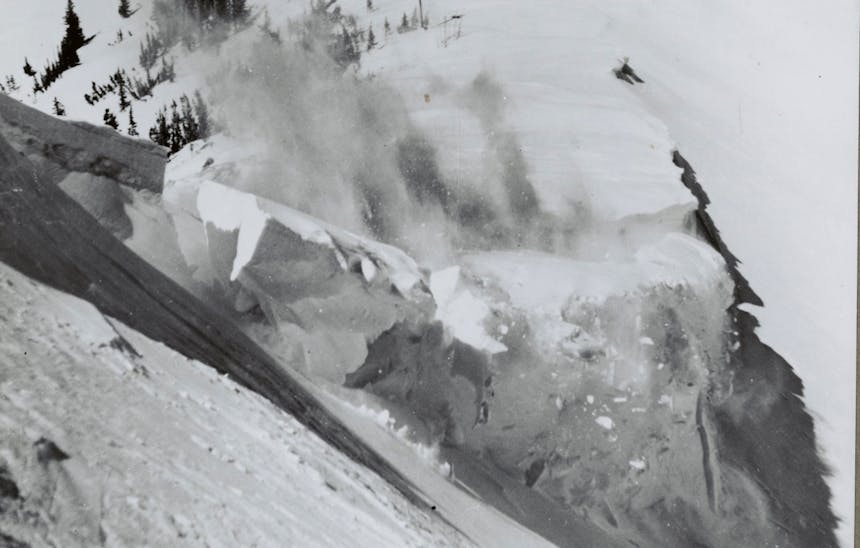 image of an avalanche in progress on the side of a snow covered mountainside